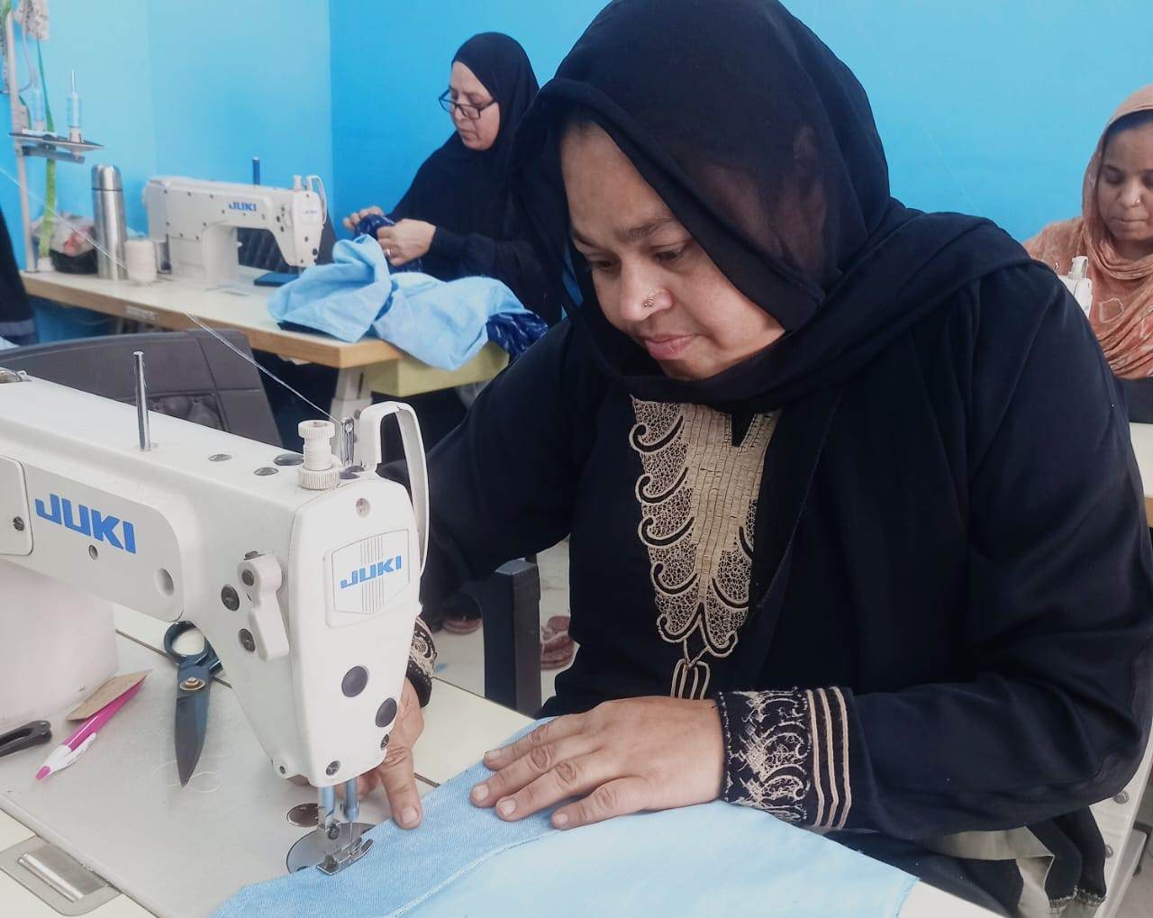 A woman support by the British Asian Trust works at her sewing machine
