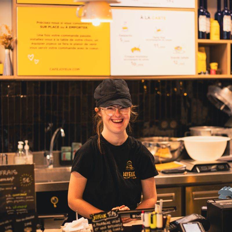 Café Joyeux employee standing behind counter