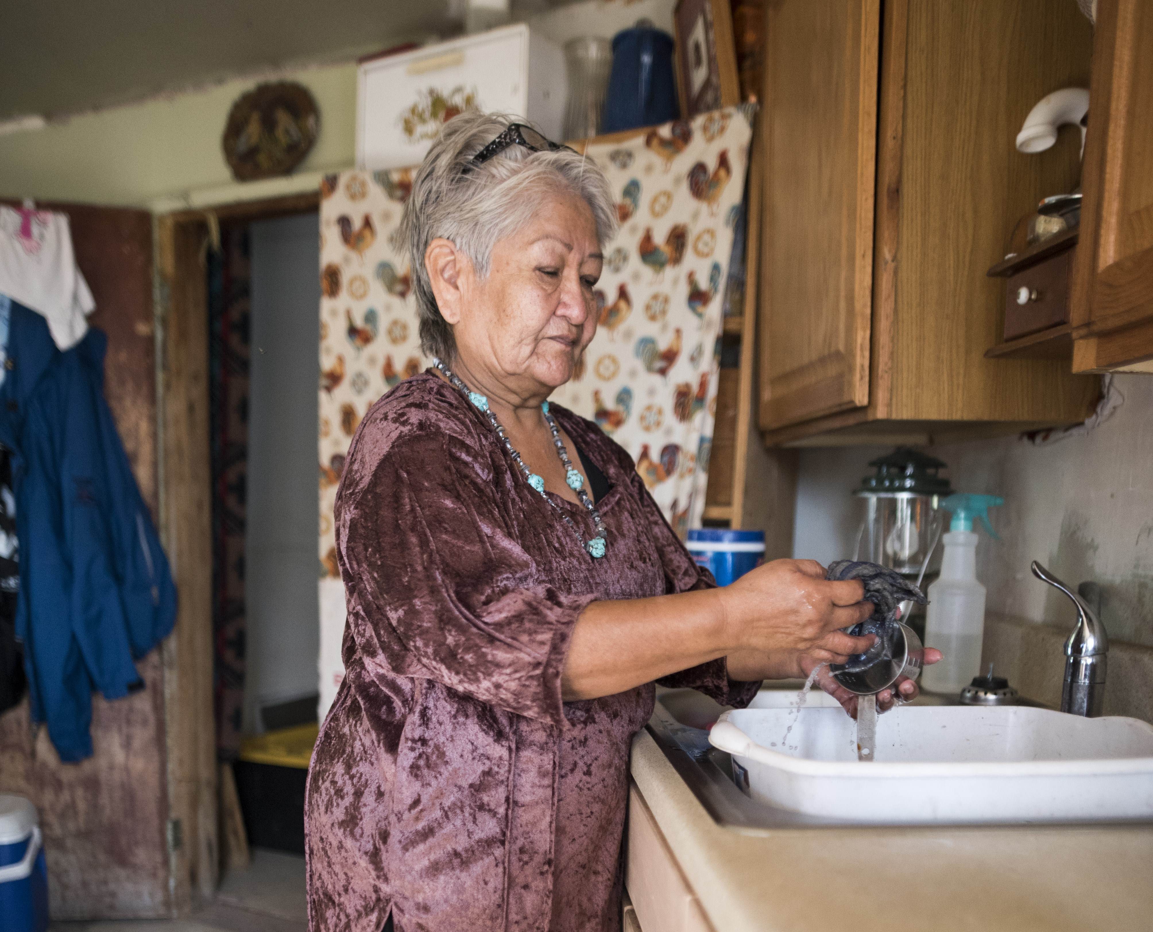 Navajo woman uses sink in home