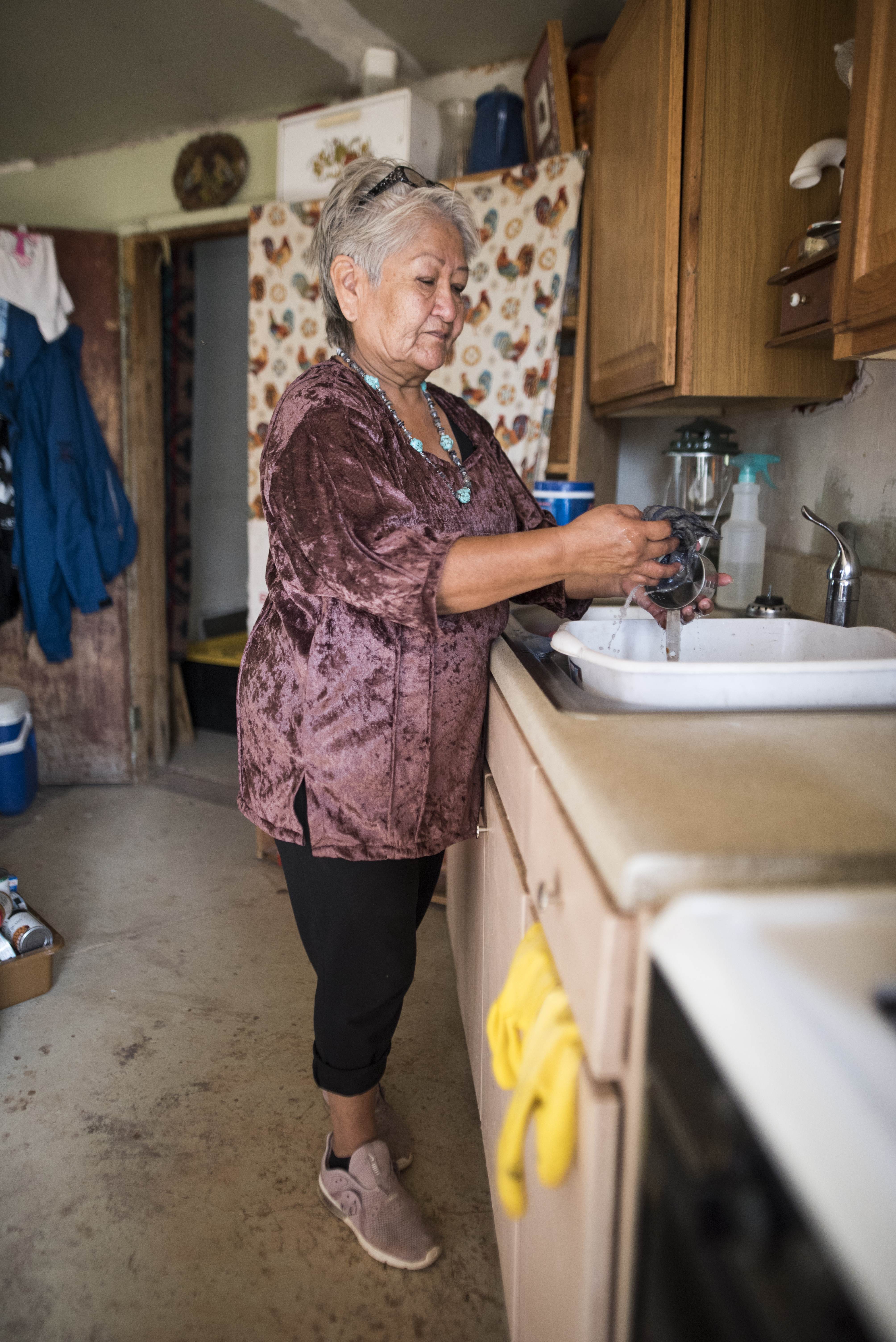 Navajo woman uses sink in home