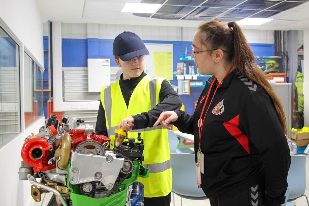Foundation of Light young man practices hands-on learning with guidance from instructor