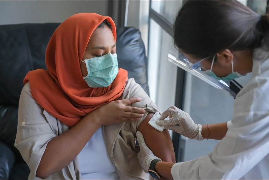 Woman receiving vaccine from doctor