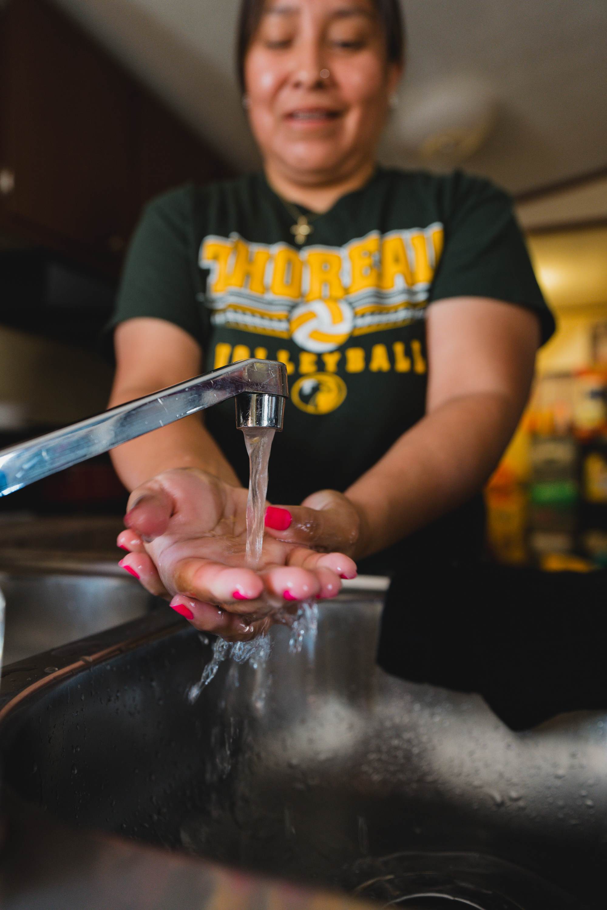 lady in USA washing hands under tap with clean running water